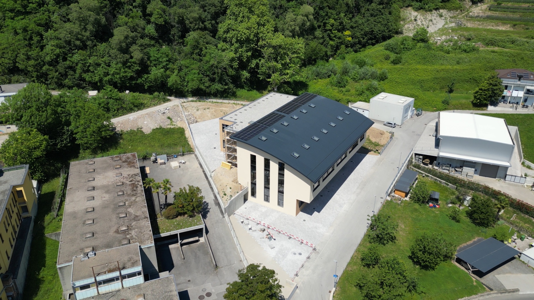 Entrance side with vertical windows and photovoltaic roof